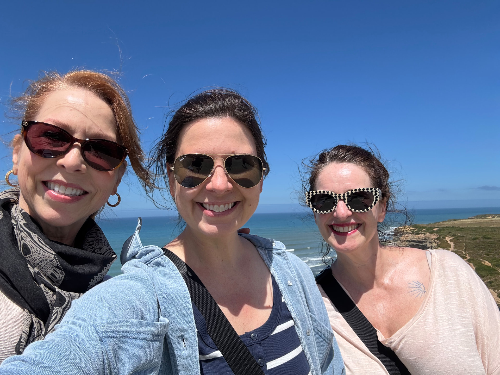 Three guests on the cliffs above the ocean in Ericeira