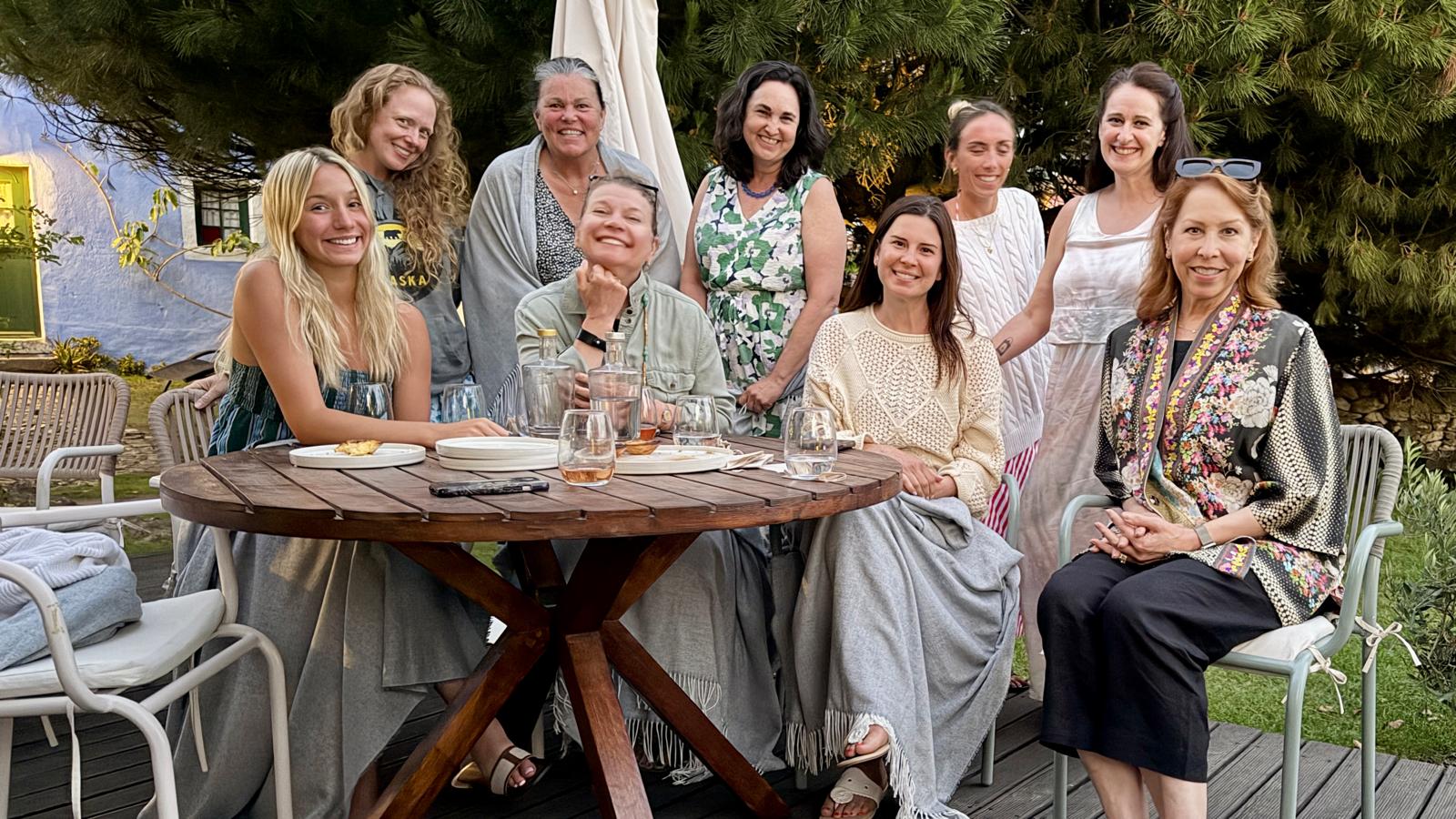 The whole group gathered around the garden table at dusk