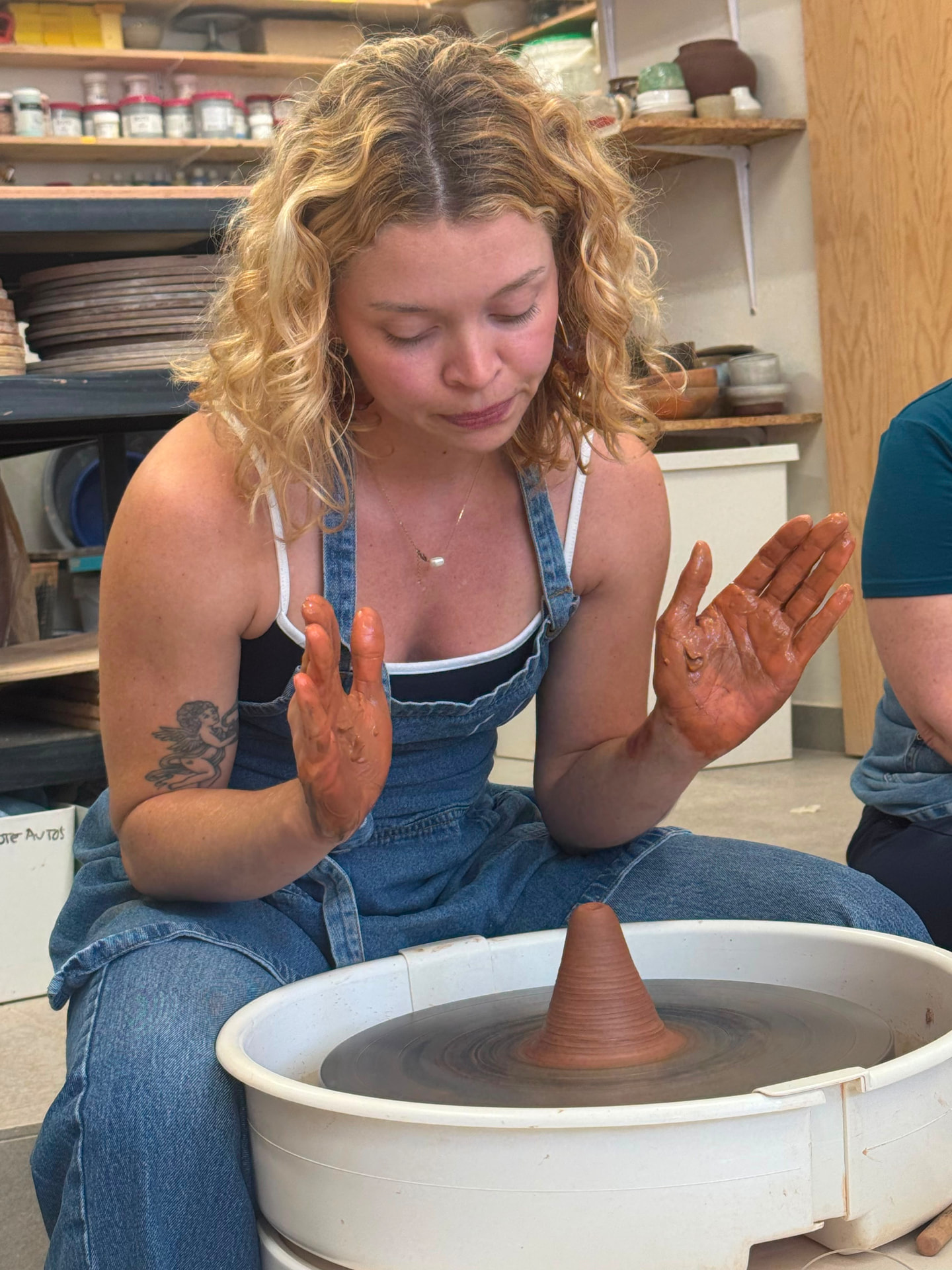 Clay-covered hands at the pottery wheel