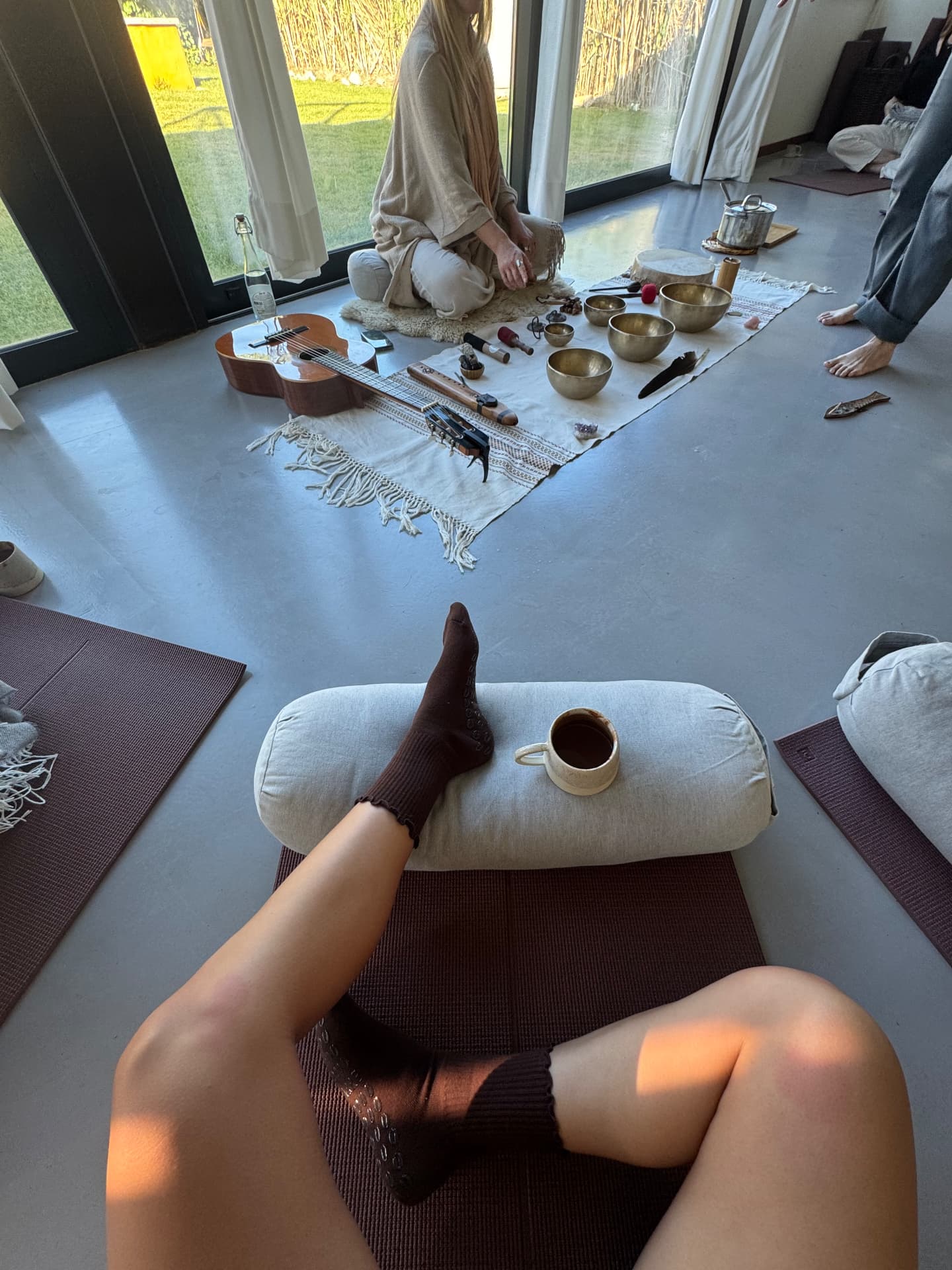 Resting on a bolster with tea during the sound bath