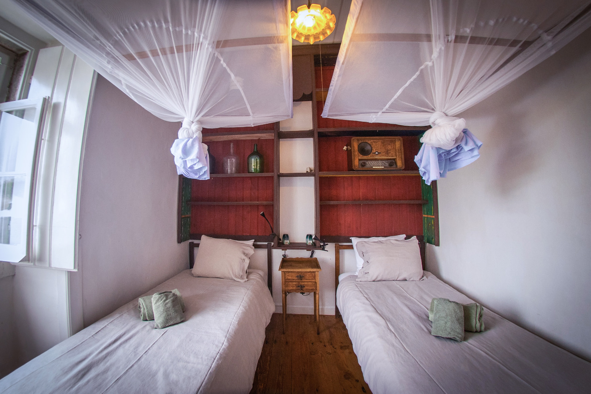 Twin beds with white canopies in Quarto Mais