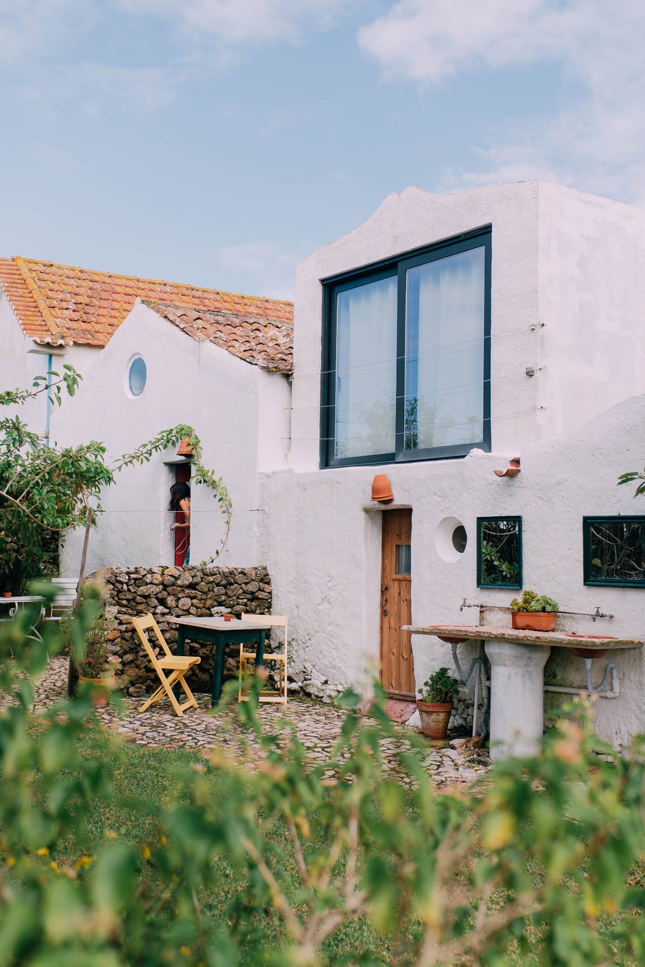 Casa Nova exterior with cobblestone courtyard and stone sink