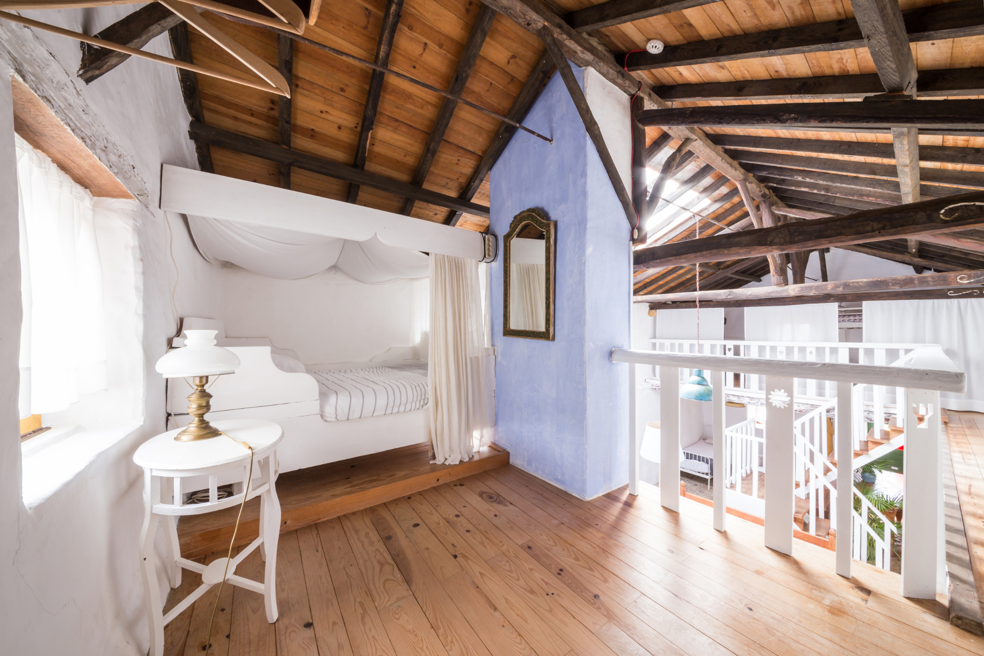 Loft bedroom under linen and exposed wooden beams