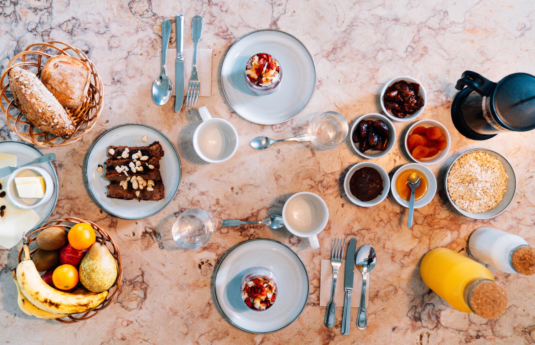 Overhead breakfast spread with bread, fruit, and coffee