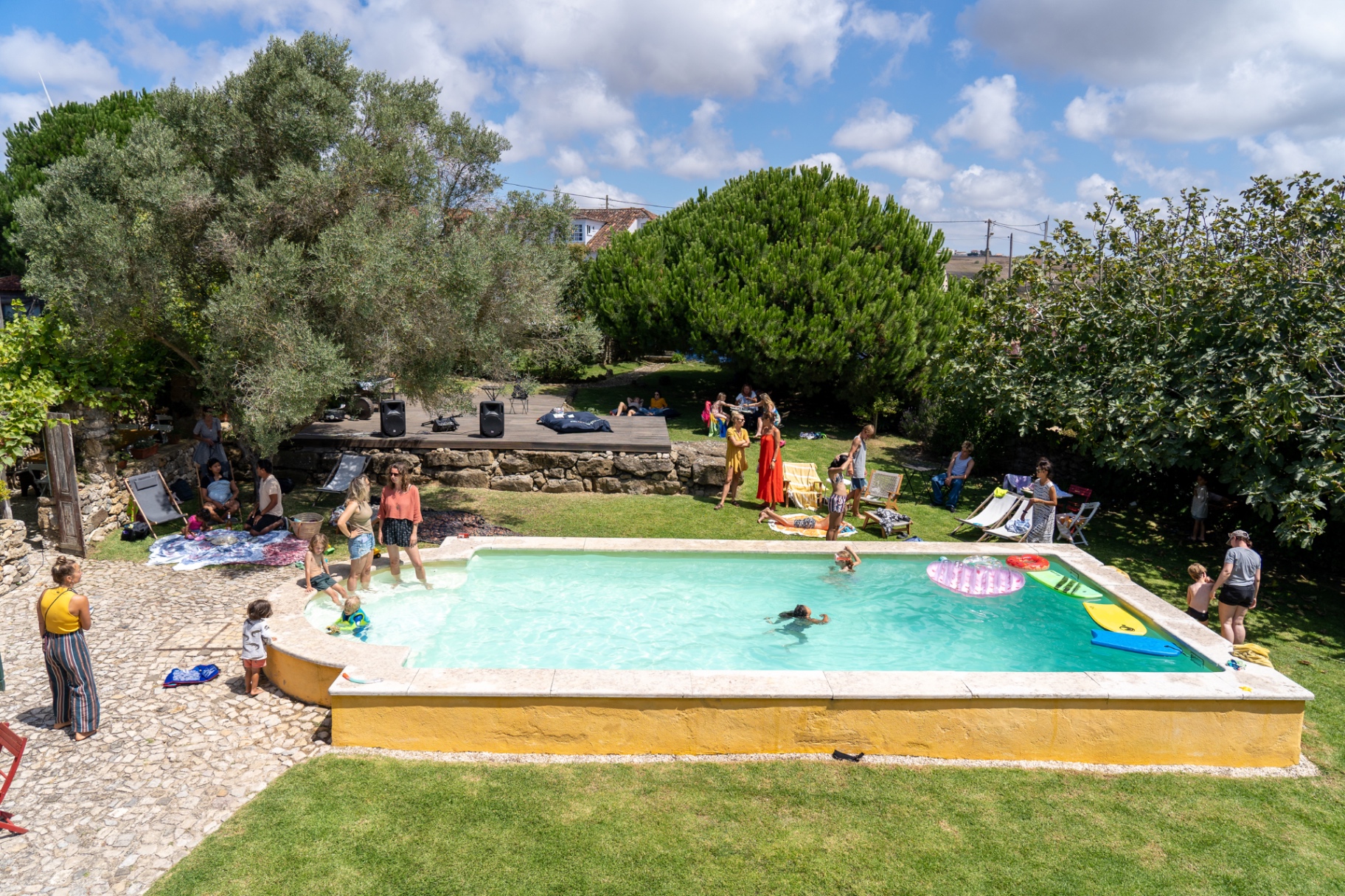Afternoon gathering by the pool with music and shade